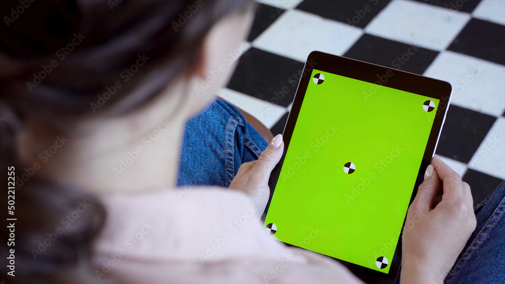 Poster close-up of man holding tablet and touching green screen. stock fooatge. young freelancer uses table