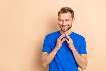 Portrait of positive cheerful man arms fingers touch look interested empty space isolated on beige...