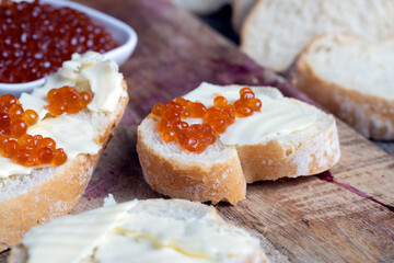 red salmon or trout caviar with white baguette and butter