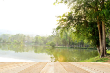 Empty top wooden table on soft blurred view at the lake with  green nature