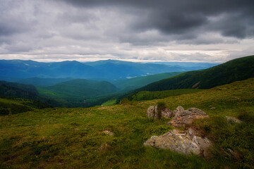 Naklejka na ściany i meble Valley in the mountains in cloudy weather, stones