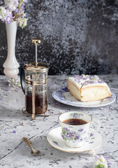 still life with black tea and cheese cake, spring bouquet,delicate lilac flowers