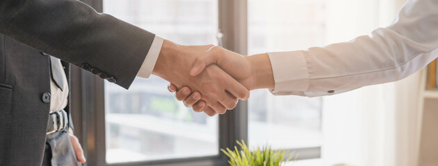 Successful asian young man, male partnership, teamwork handshake or greeting together at office after project done, good deal. Happy business people, worker or group meeting, shaking hands concept.