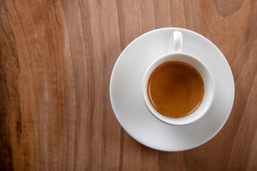 White cup of espresso on wooden background,top view