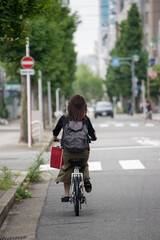 名古屋の街で自転車に乗っている若い女性の姿