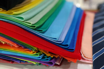 Colorful and multi-colored fabrics are stacked.