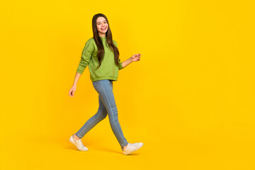 Fototapeta na wymiar Full size profile side photo of young lovely girl walk empty space wear modern outfit isolated over yellow color background