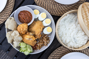 Nasi lemak with fried chicken, anchovis, eggs, groundnuts and sambal is popular Malaysia delicacy, served with rice cooked in coconut milk