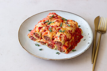 Cannelloni with meat, cheese, tomatoes and thyme. Italian cuisine.