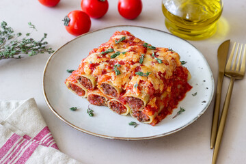 Cannelloni with meat, cheese, tomatoes and thyme. Italian cuisine.