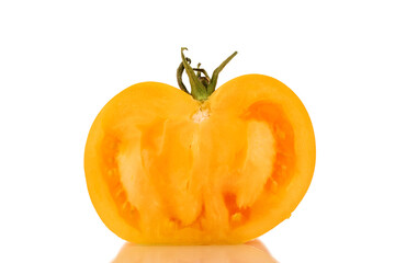 One half of an organic yellow tomato, close-up, isolated on a white background.