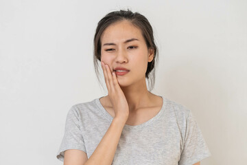 Closing eyes asian young woman touching cheek, face expression from toothache, tooth decay or sensitivity, Having tooth or teeth problem or inflammation, suffering from health. Sensitive teeth people