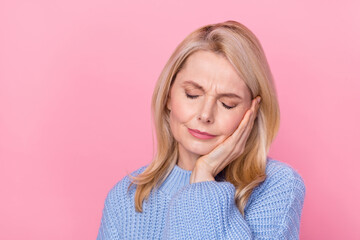 Photo of pain mature blond lady hand cheek wear blue sweater isolated on pink color background