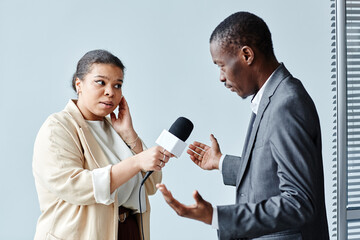 Side view portrait of African American young woman interviewing business expert, minimal