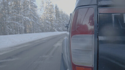 Obraz na płótnie Canvas Headlight closeup on snowy roads. The car rides on a snow-covered road