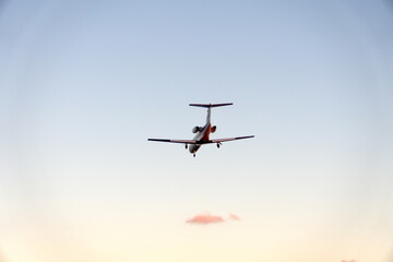 Private jet flying in silhouette, in the evening, in Fort Lauderdale, Florida, USA