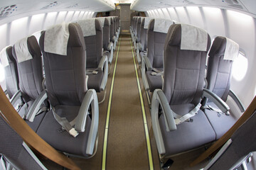 Aircraft interior. The passenger cabin of modern passenger airplane. Aisle between seats.
