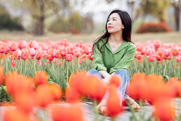 Candid lifestyle Portrait of happy young beautiful asian sexy woman enjoying life outdoor in park at spring. Smiling millennial girl with perfect clear glow skin and long brunette hair