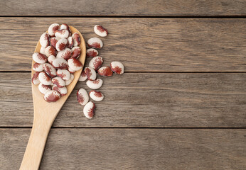 Rajado red beans in a spoon over wooden table with copy space