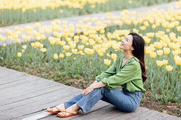 Candid lifestyle Portrait of happy young beautiful asian sexy woman enjoying life outdoor in park at spring. Smiling millennial girl with perfect clear glow skin and long brunette hair