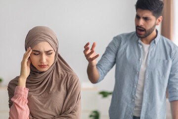 Mad Middle Eastern Husband Yelling At Scared Wife At Home - obrazy, fototapety, plakaty
