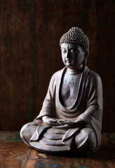 Meditating Buddha Statue on dark wooden background. Close up.	