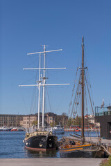 Old sail boats at a pier in the bay Ladugårdsgärdesviken a sunny spring day in Stockholm