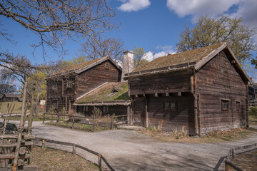 Fototapeta na wymiar Three part old 1800s log house in a park a sunny spring day in Stockholm