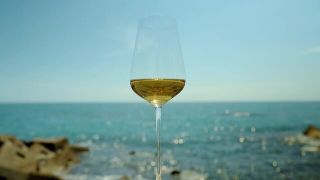 White wine in glass against the sea
