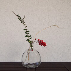 Still life with branches and red berries. Japanese art of flower arrangement. Ikebana arrangement.
