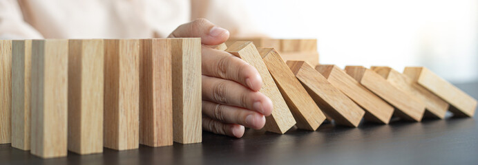 Businesswoman stops hands falling over domino to stop risk continuously, Continuous damage...