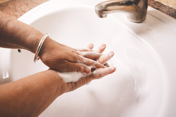 Asian eldery woman washing hand by foam soap for hygiene at home