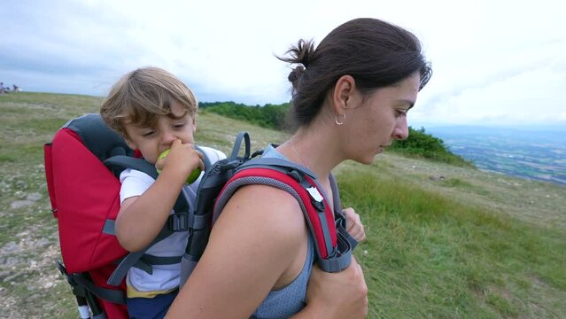Mother and child together hiking in nature kid eating green apple outdoors