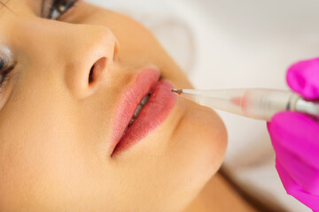  Young woman having permanent makeup on lips in beautician salon, closeup