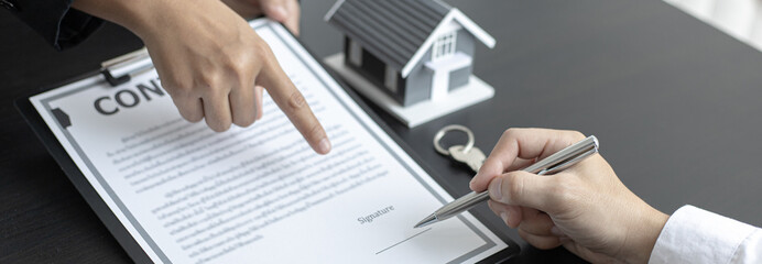 Real estate agent talked about the terms of the home purchase agreement and asked the customer to sign the documents to make the contract legally, Home sales and home insurance concept.
