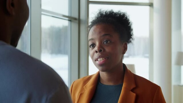 Businesswoman Talking To Businesman In Front Of Window