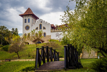 Purcari, Moldova 27.04.2022. Modern winery Chateau Purcari in Purcari village, Moldova, on a clody spring day, Greenery, wooden bridge, lake, logo, white swan, belvedere, vineyard