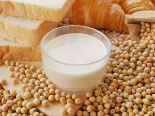 Delicious hot soy milk on lots of soy beans with sack of soy beans and some croissant and some breads