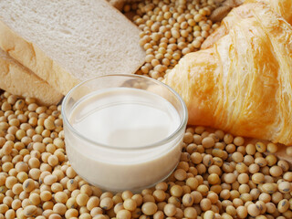 Glass of soy milk on soy bean and some bread and delicious croissant