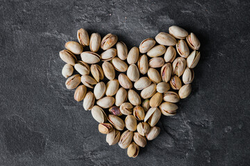 Pistachios on a black background in the form of heart