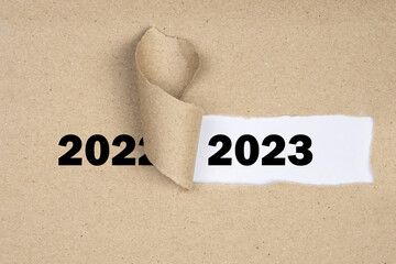 Message Year 2022 replaced by 2023 torn craft paper texture background.
Good bye 2022 hello to 2023...