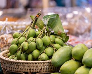 Group of raw green mangoes in basket for sale in the market