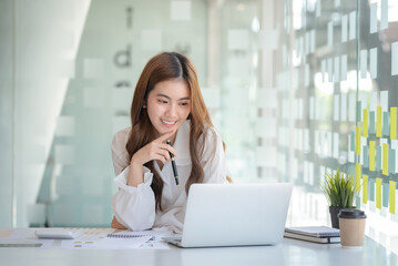 Obraz premium Beautiful Asian business woman sitting working on laptop computer and document in the office.