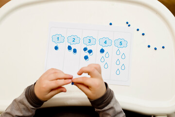 Early education, learning to count. 2 year old boy puts correct amount of play dough to assigned number. Montessori concept. formation and development of the child.