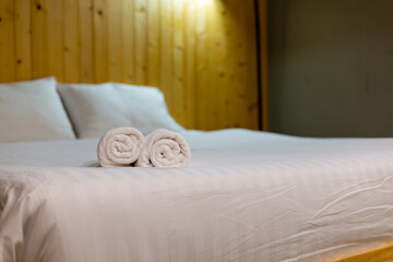 White towel on bed in guest room for hotel customer.