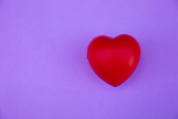 Obraz premium Red heart shape on a lilac background.Top view. Copy space.MOCKUP Concept of love and health.