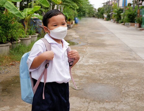 Portrait of Asian boy student in school uniform wearing a white shirt with backpack wearing mask go to school, back to school concept during the covid 19 epidemic