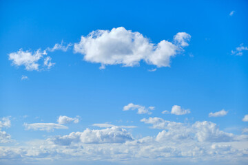 Blue sky with white cumulus clouds. Bright sunny day with cloudy sky