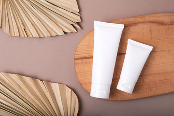 Top view of two blank cosmetics tubes on wooden podium.Earth tones,eco friendly concept.