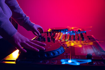 Close-up image of male hands, dj making sounds at night club party with professional sound mixer....